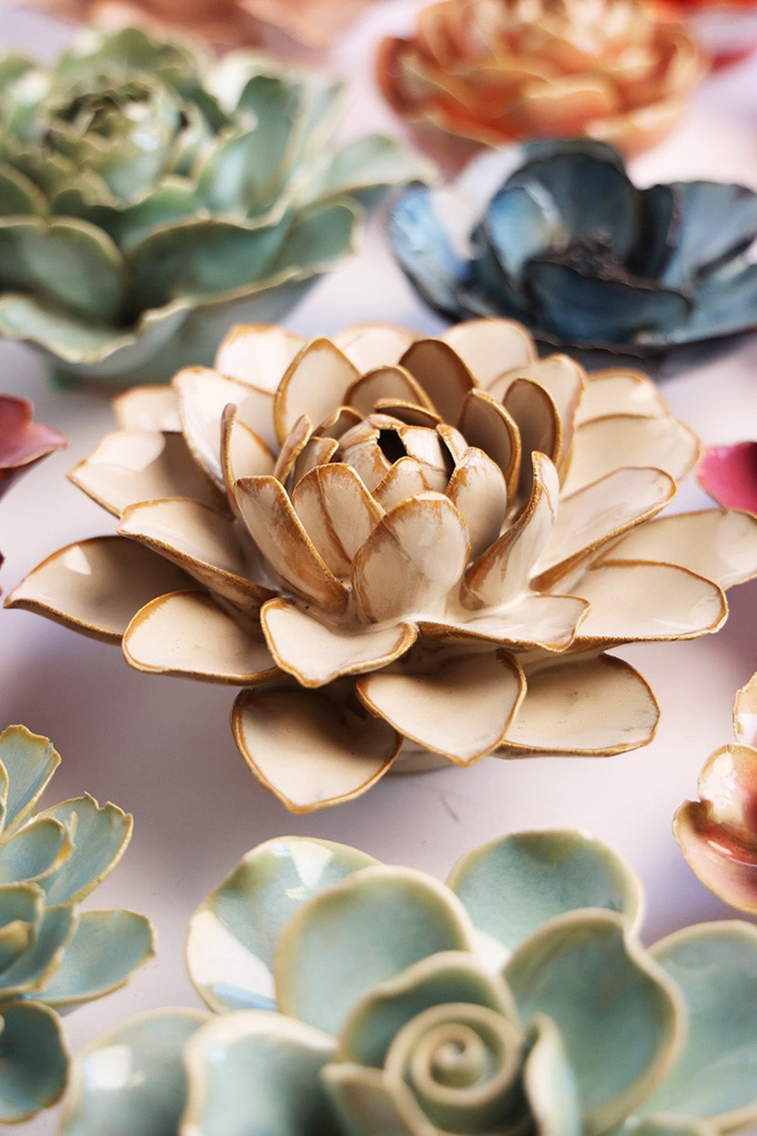 Oatmeal Water Lily ceramic wall flower styled on a white table with other flowers — Chive Studio