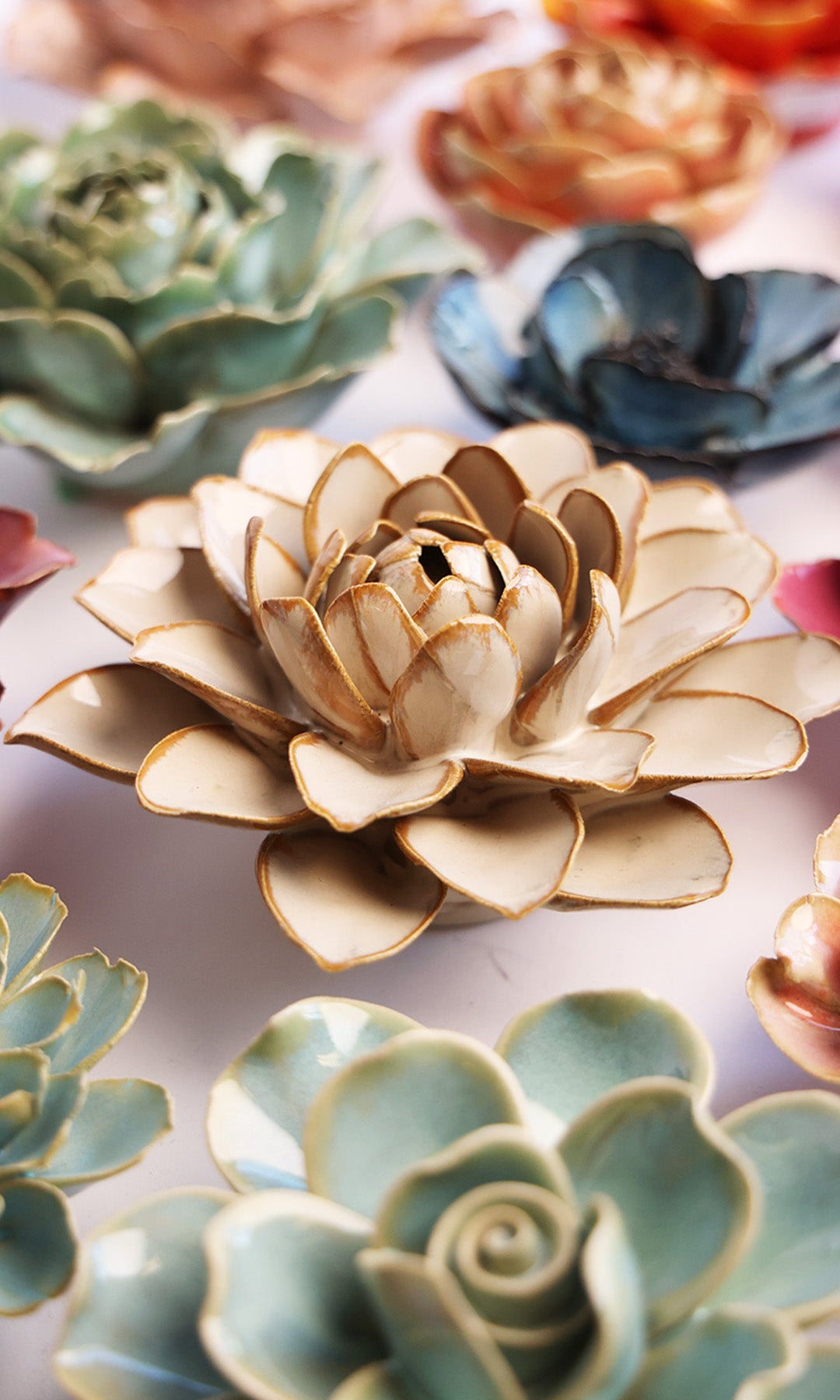 Oatmeal Water Lily ceramic wall flower styled on a white table with other flowers — Chive Studio