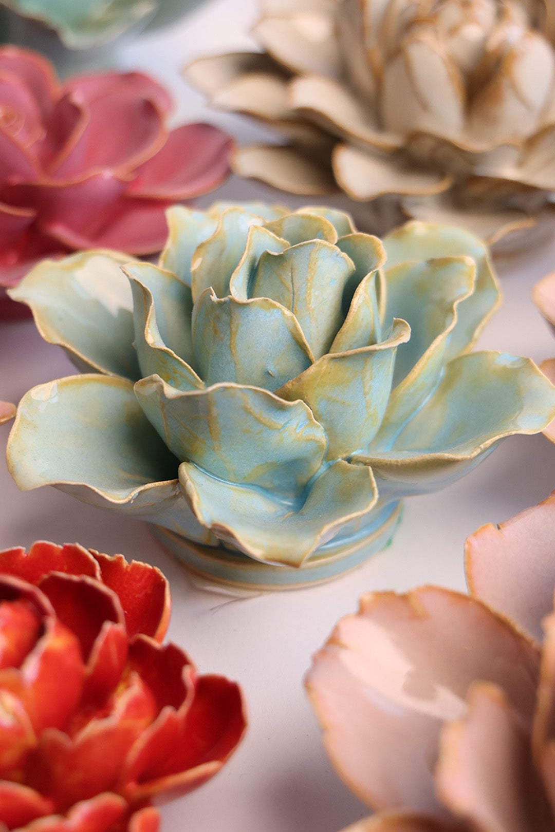 Robin's Egg Blue Lily ceramic wall flower styled on a white table with other flowers — Chive Studio