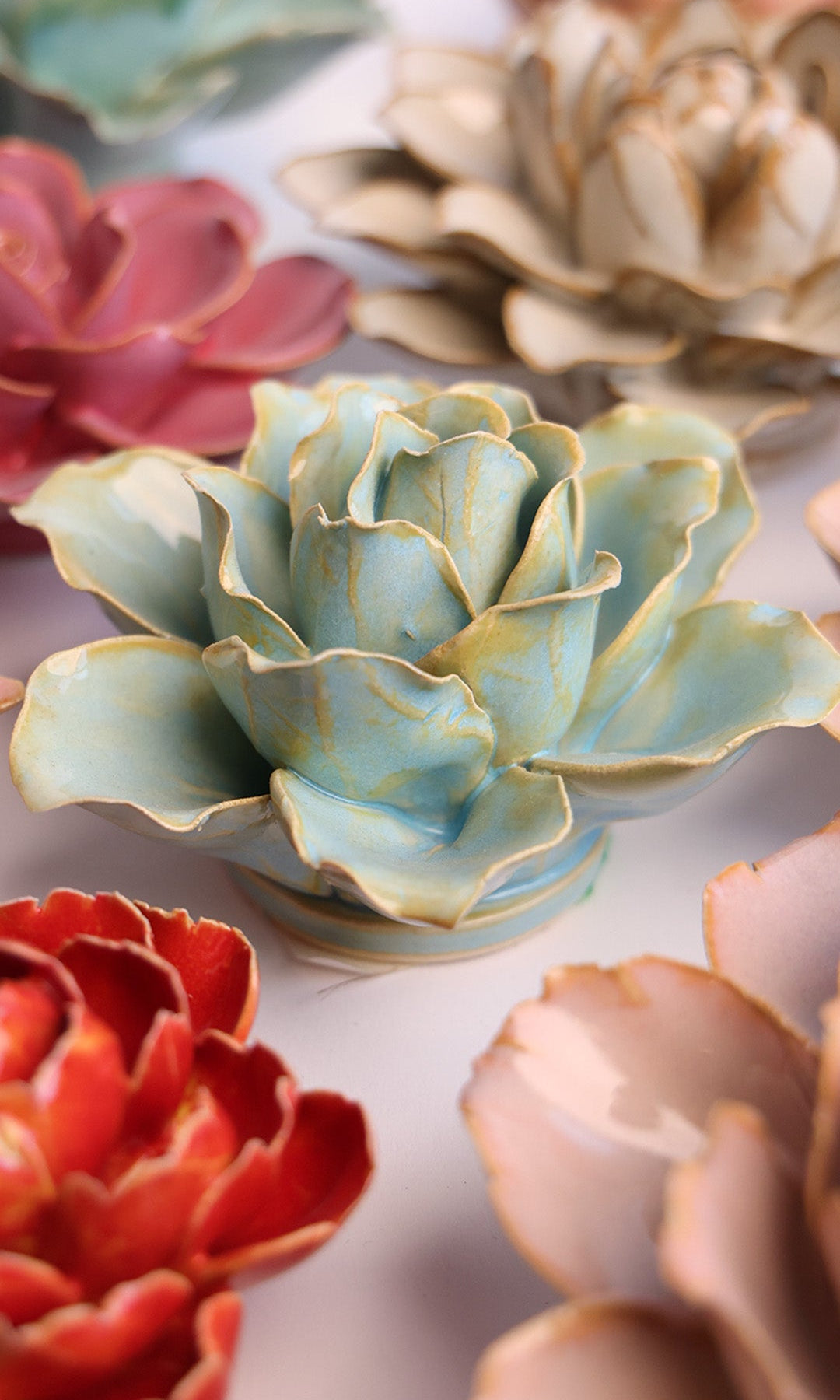 Robin's Egg Blue Lily ceramic wall flower styled on a white table with other flowers — Chive Studio