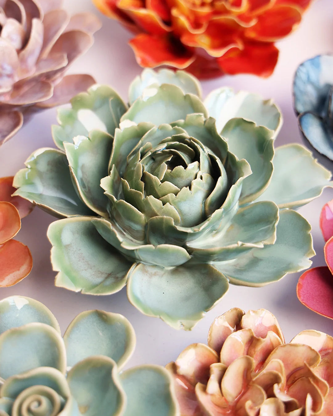 Milk Teal Camellia ceramic wall flower mounted on a wall — Chive Ceramics Studio
