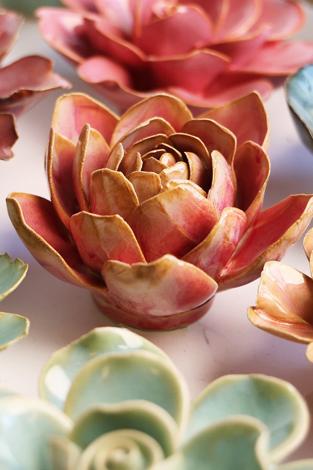 Rose Quartz Narcissus ceramic wall flower styled on a white table with other flowers — Chive Studio