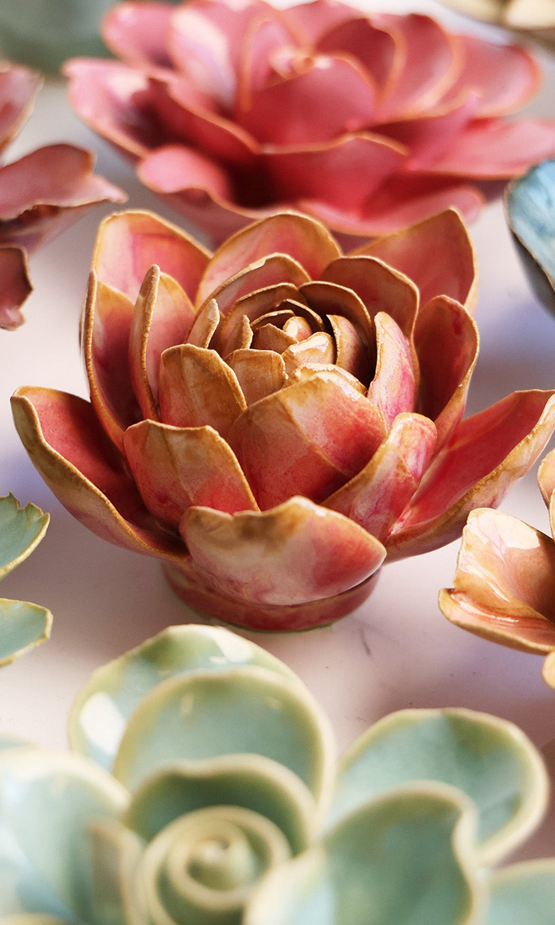 Rose Quartz Narcissus ceramic wall flower styled on a white table with other flowers — Chive Studio