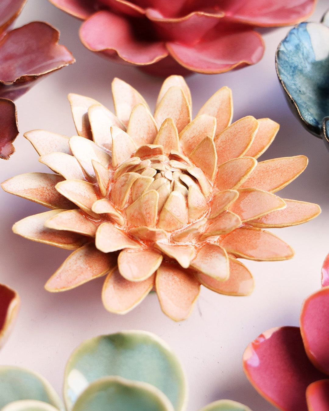 Peach Pink Strawflower ceramic wall flower styled on a white table with other flowers — Chive Studio