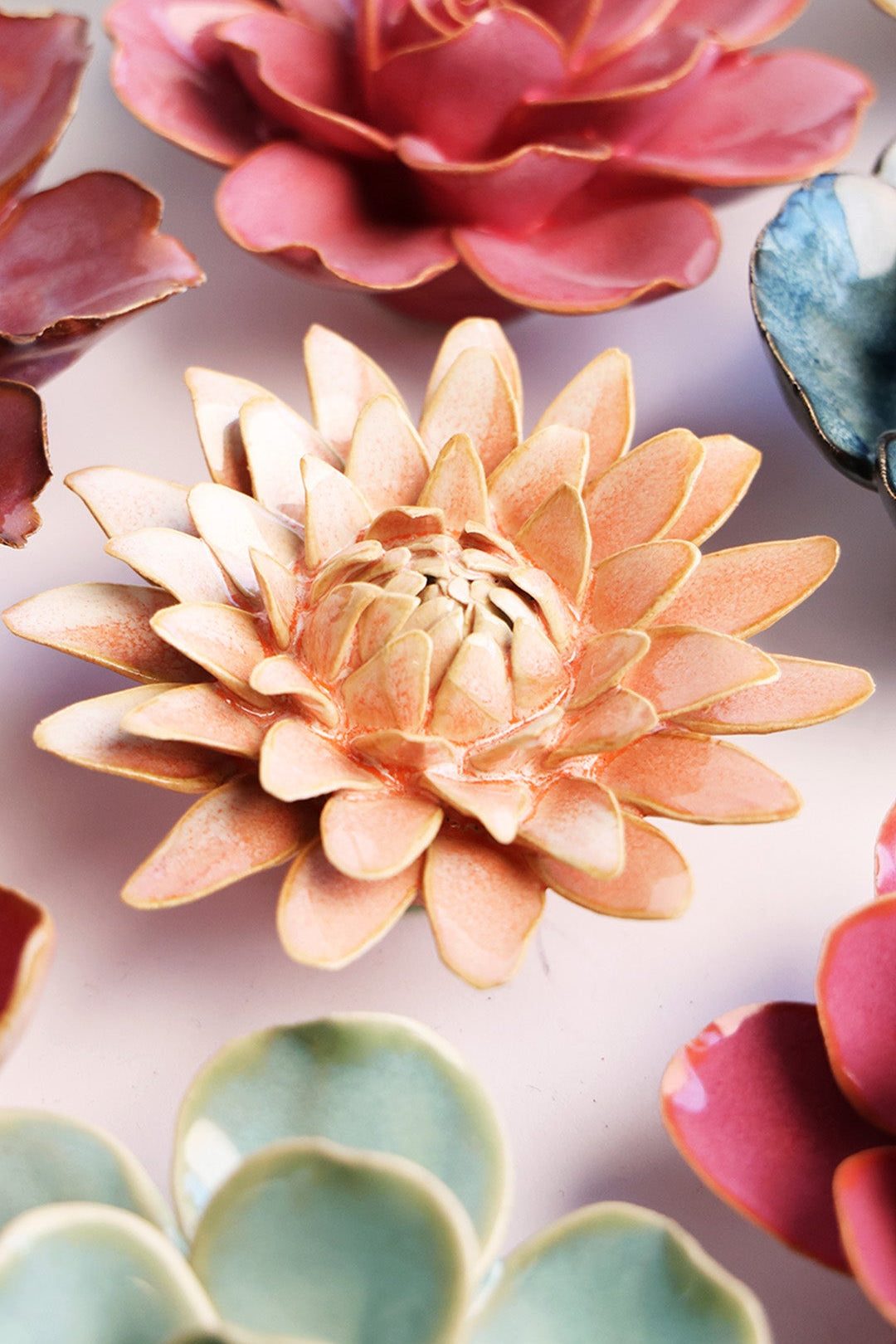 Peach Pink Strawflower ceramic wall flower styled on a white table with other flowers — Chive Studio