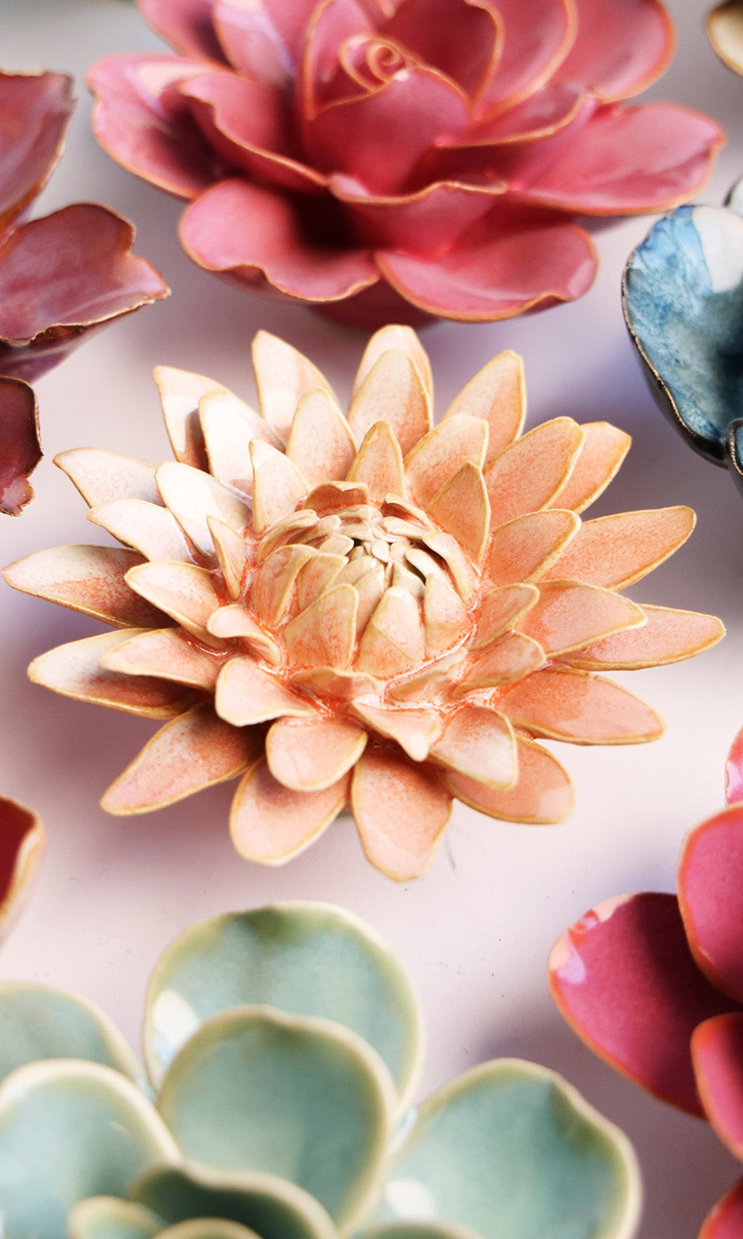 Peach Pink Strawflower ceramic wall flower styled on a white table with other flowers — Chive Studio