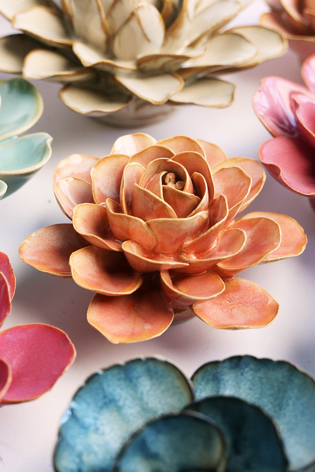 Peach Pink Begonia ceramic wall flower styled on a white table with other flowers — Chive Studio