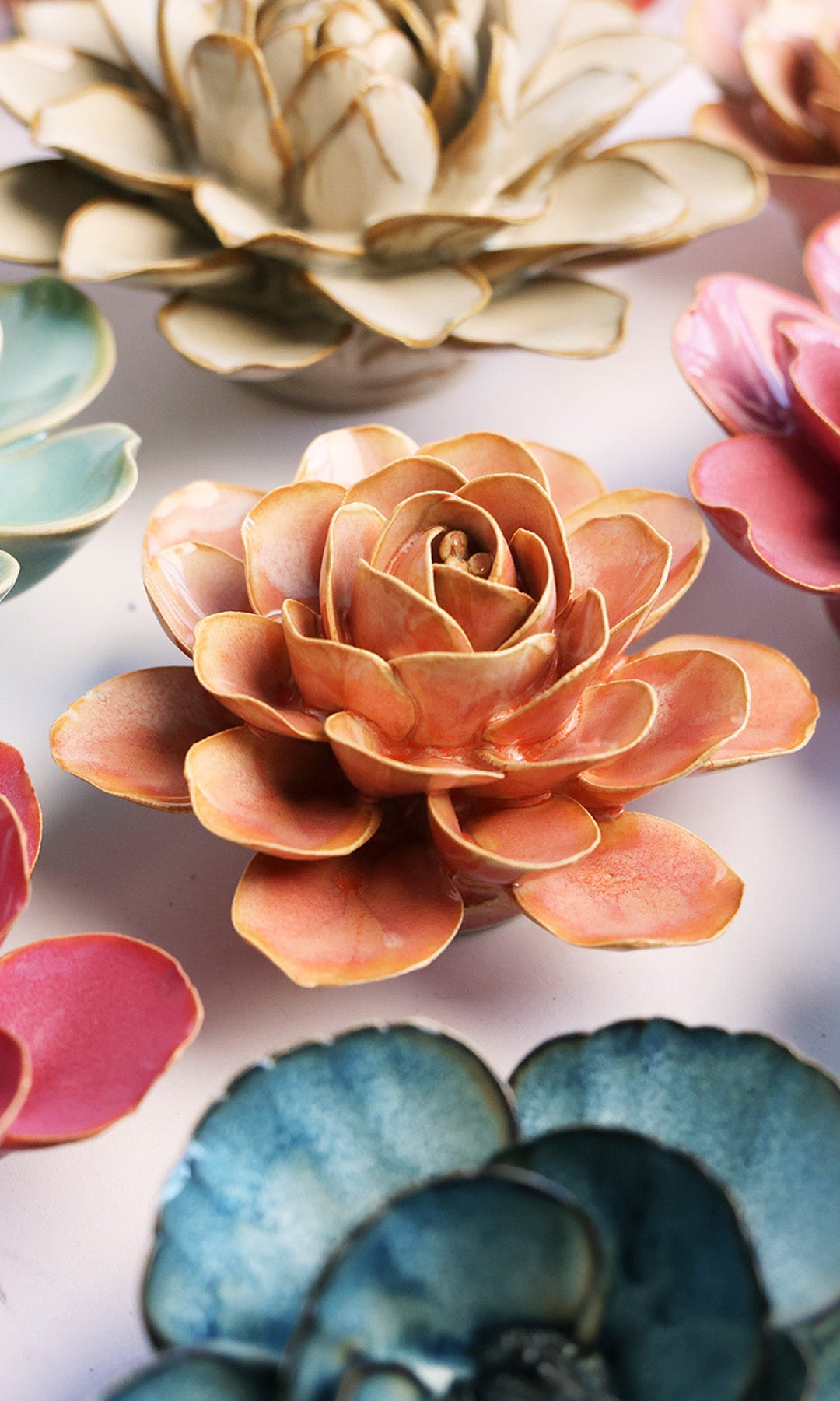 Peach Pink Begonia ceramic wall flower styled on a white table with other flowers — Chive Studio