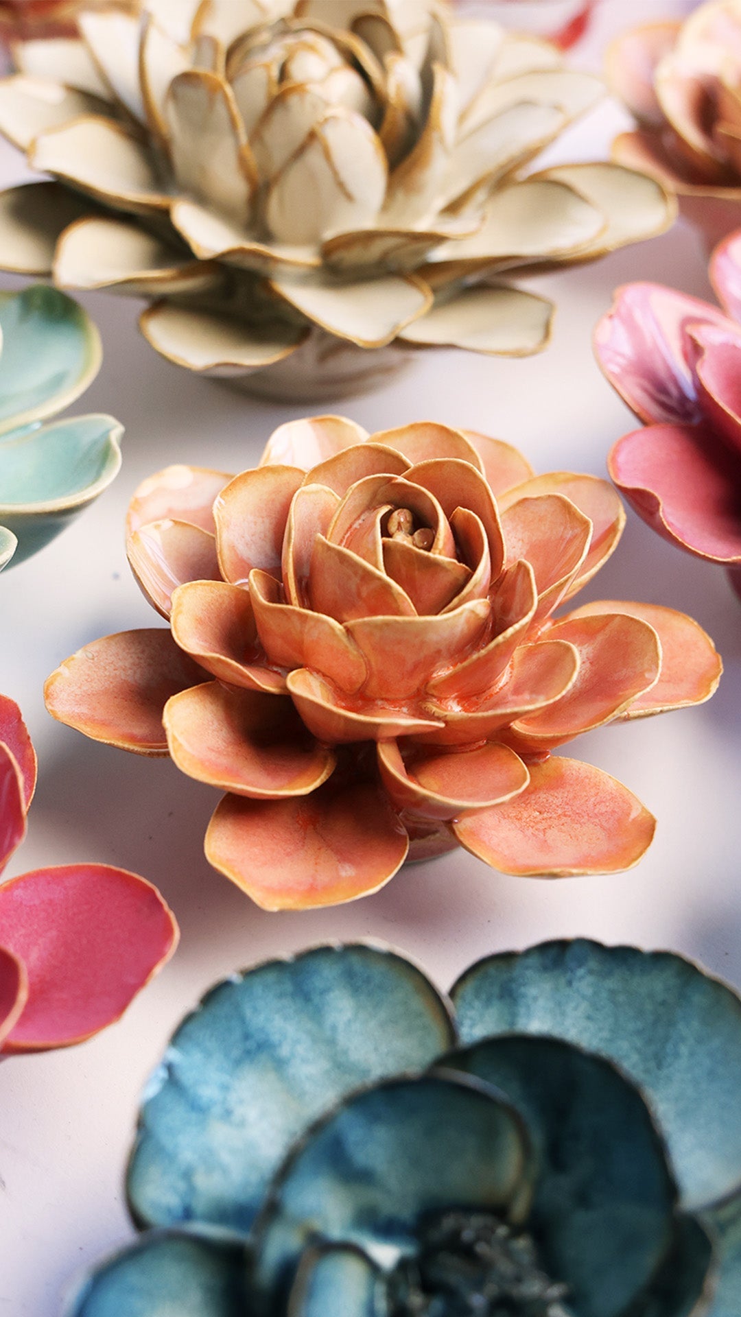 Peach Pink Begonia ceramic wall flower styled on a white table with other flowers — Chive Studio