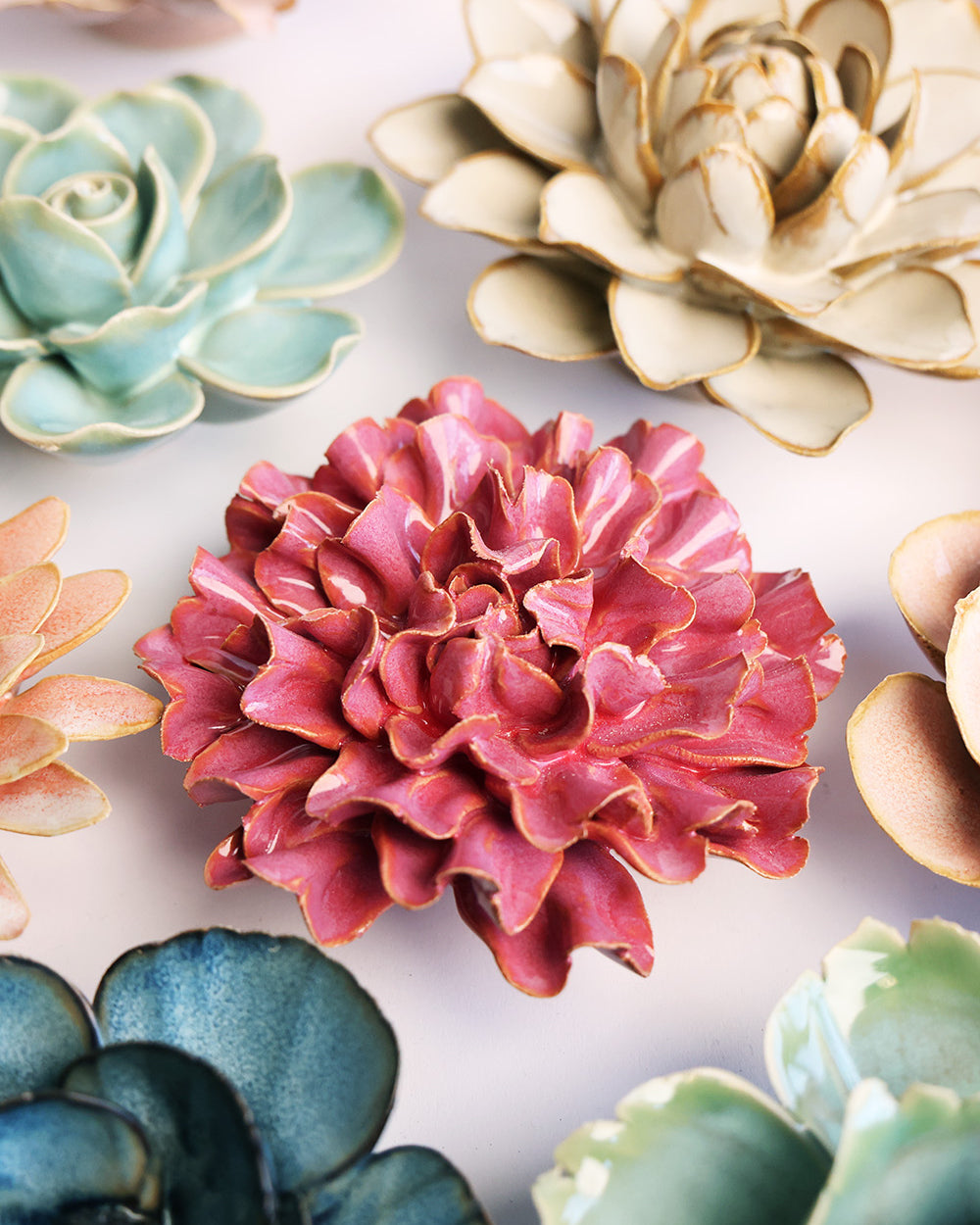 Blush Pink Tundra Carnation ceramic wall flower mounted on a wall — Chive Ceramics Studio