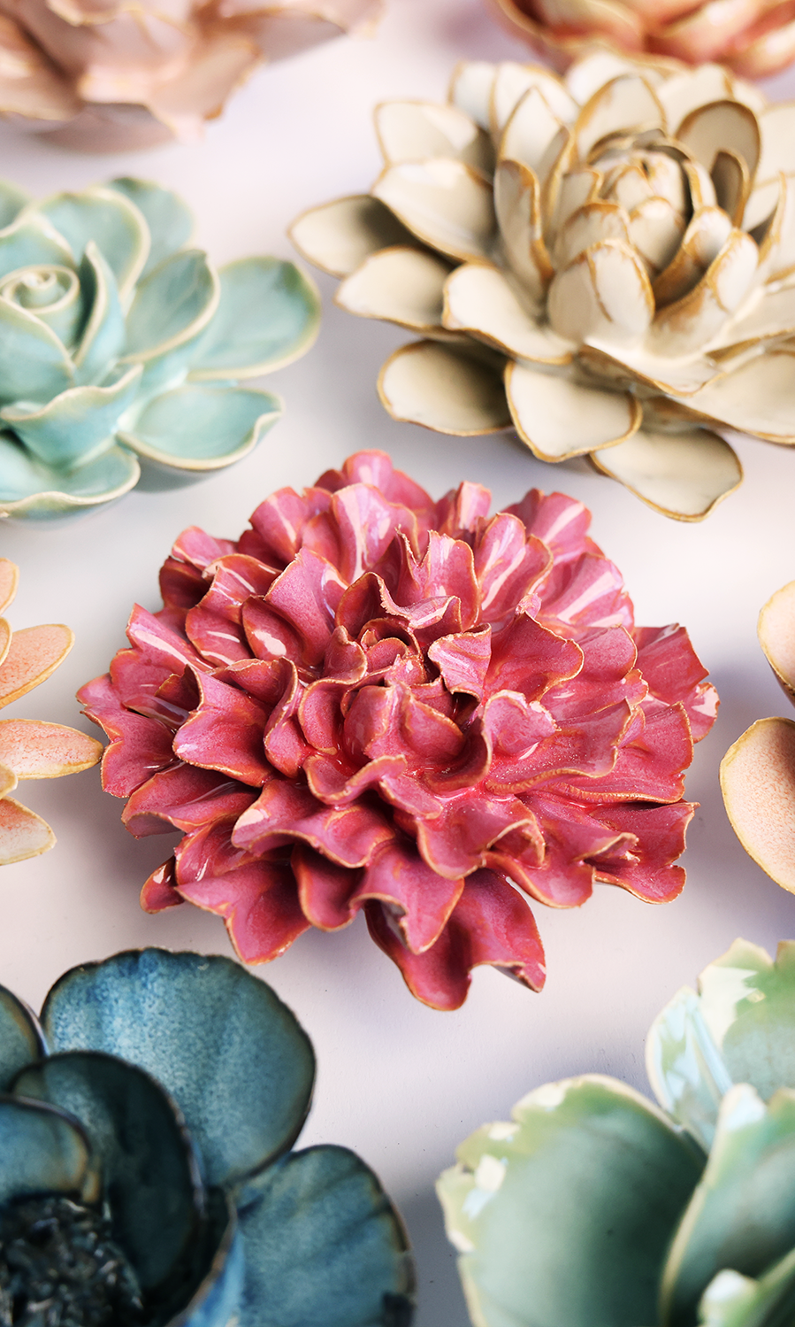Blush Pink Carnation ceramic wall flower styled on a white table with other flowers — Chive Studio