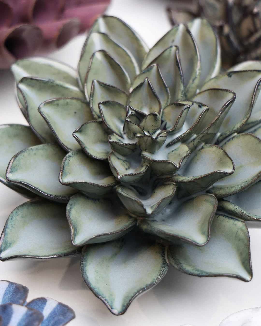 Grey Goyet Azalea ceramic wall flower styled on a white table with other flowers — Chive Studio