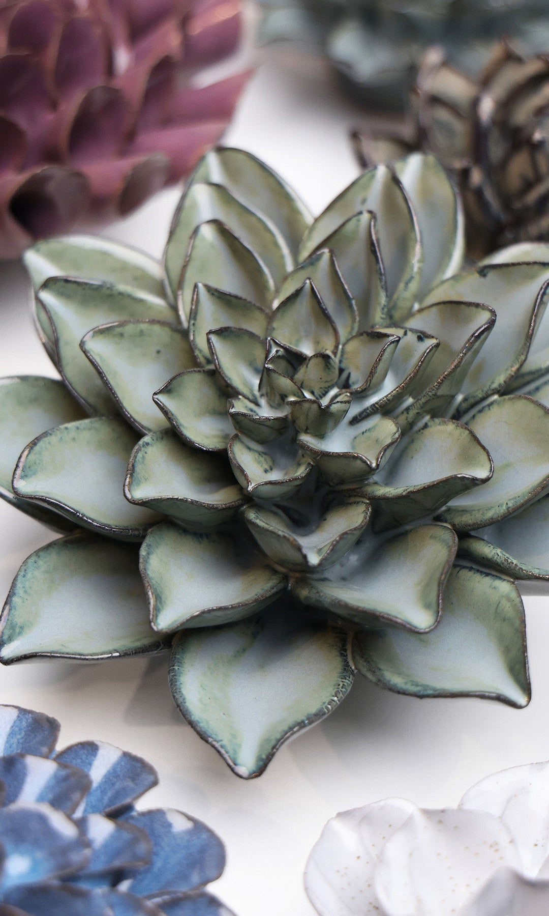 Grey Goyet Azalea ceramic wall flower styled on a white table with other flowers — Chive Studio