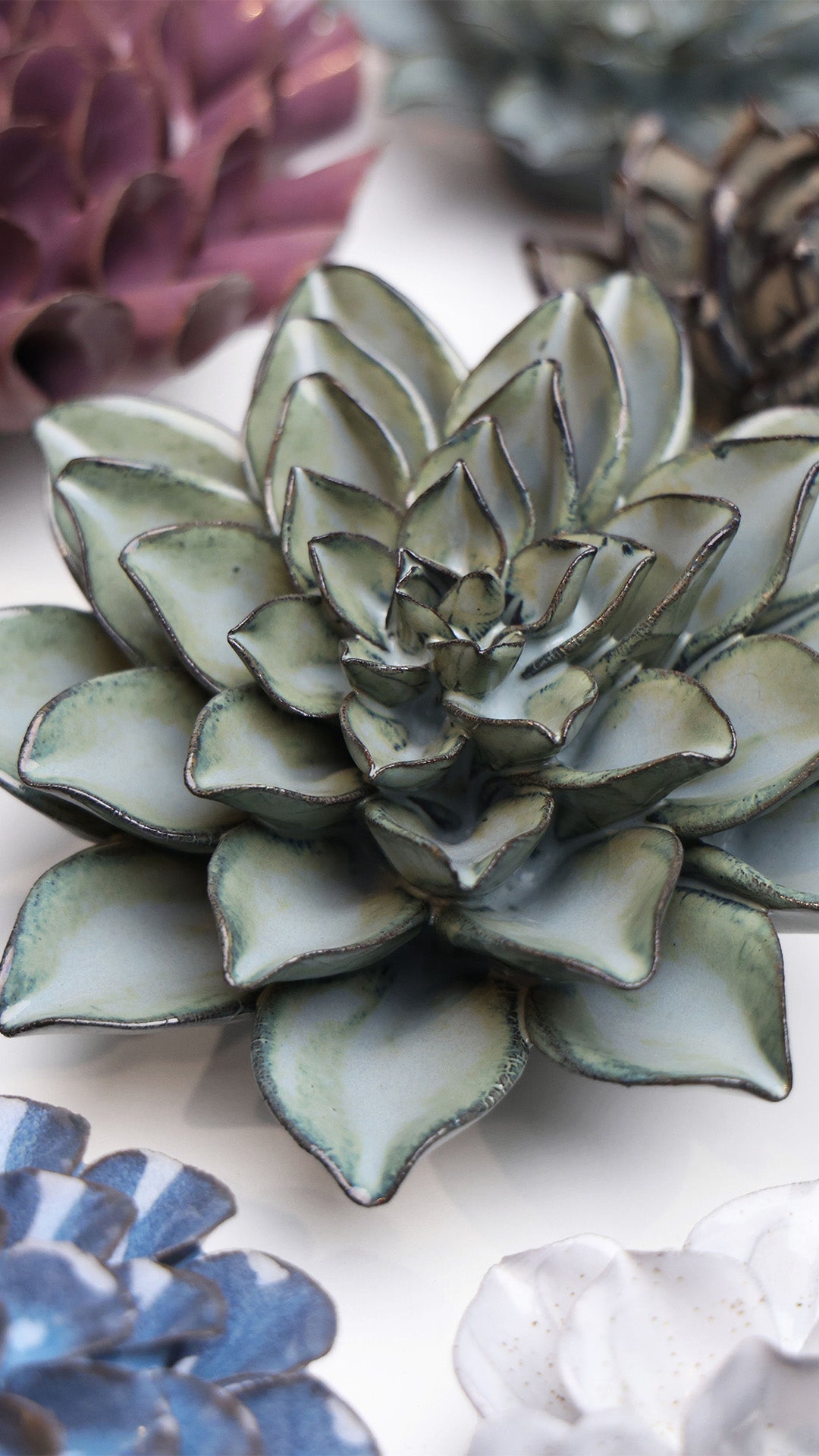 Grey Goyet Azalea ceramic wall flower styled on a white table with other flowers — Chive Studio