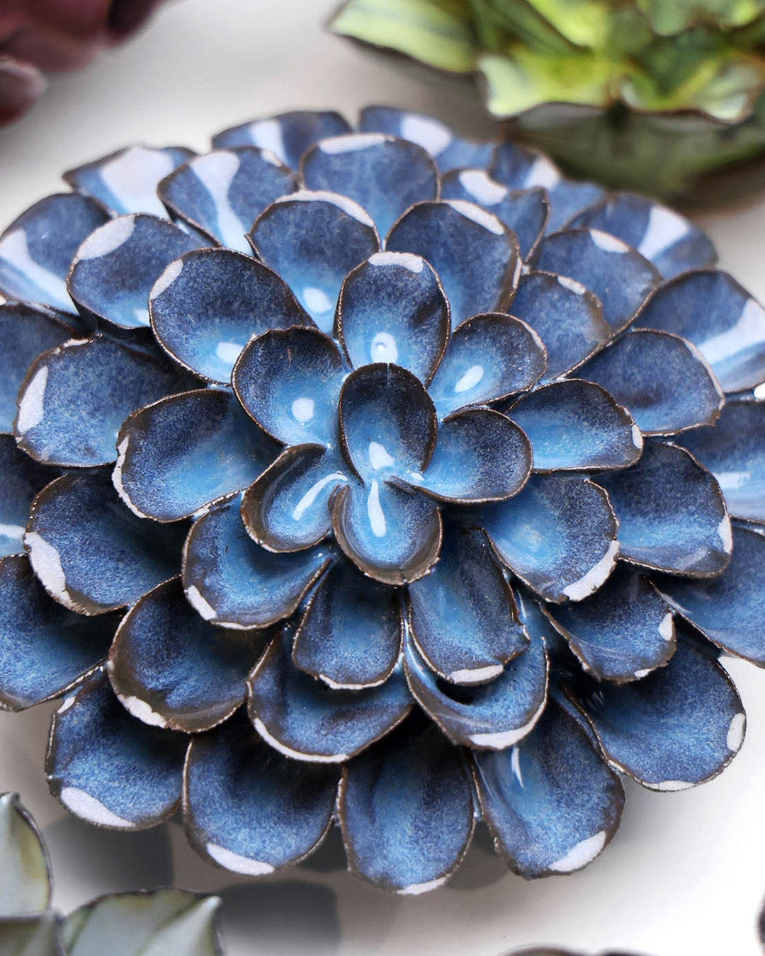 Blue Dahlia ceramic wall flower styled on a white table with other flowers — Chive Studio