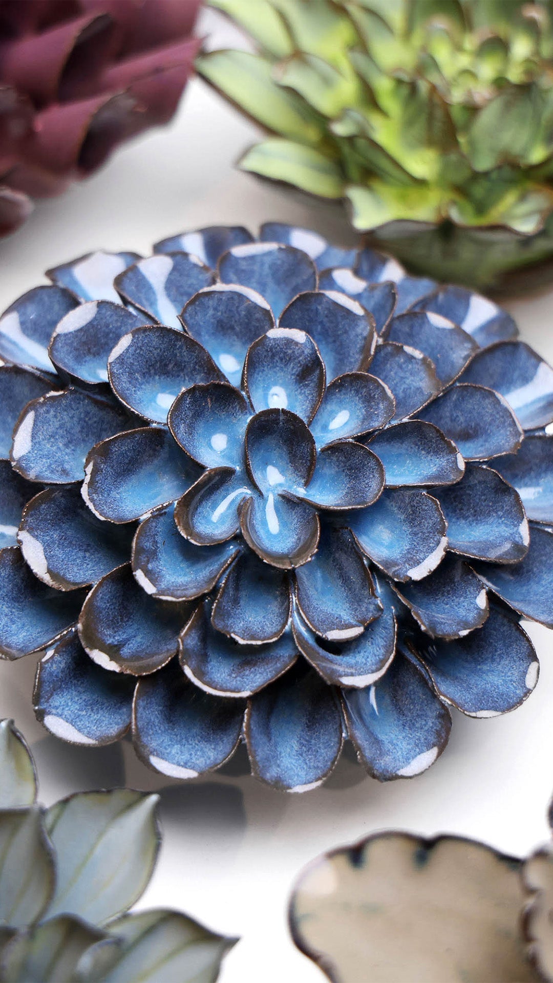 Blue Dahlia ceramic wall flower styled on a white table with other flowers — Chive Studio