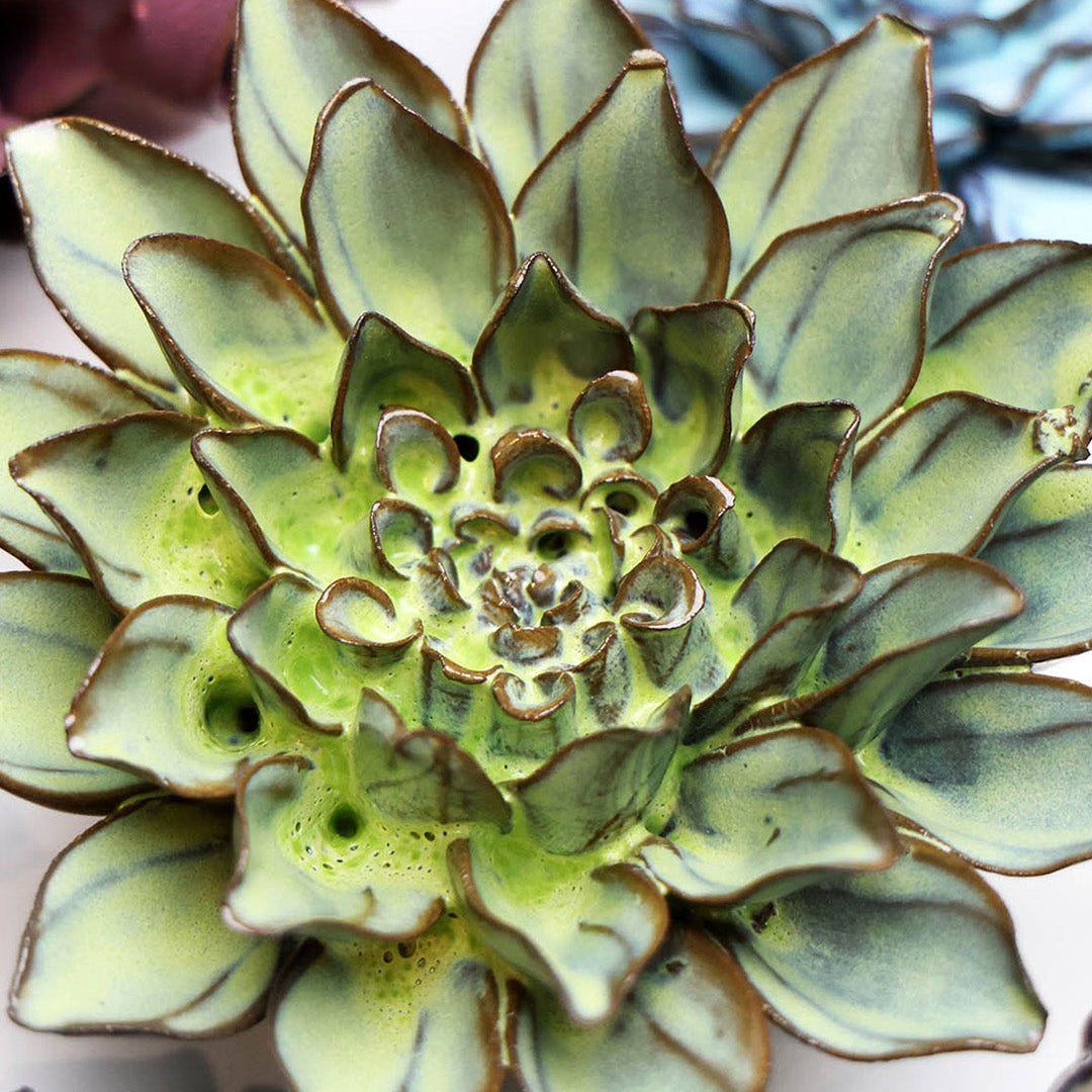 Green Aster ceramic wall flower styled on a white table with other flowers — Chive Studio