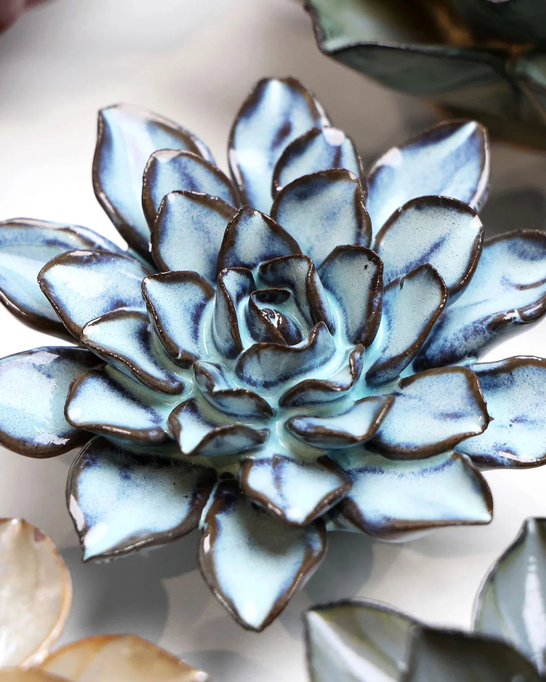 Blue Alpine Aster ceramic wall flower styled on a white table with other flowers — Chive Studio