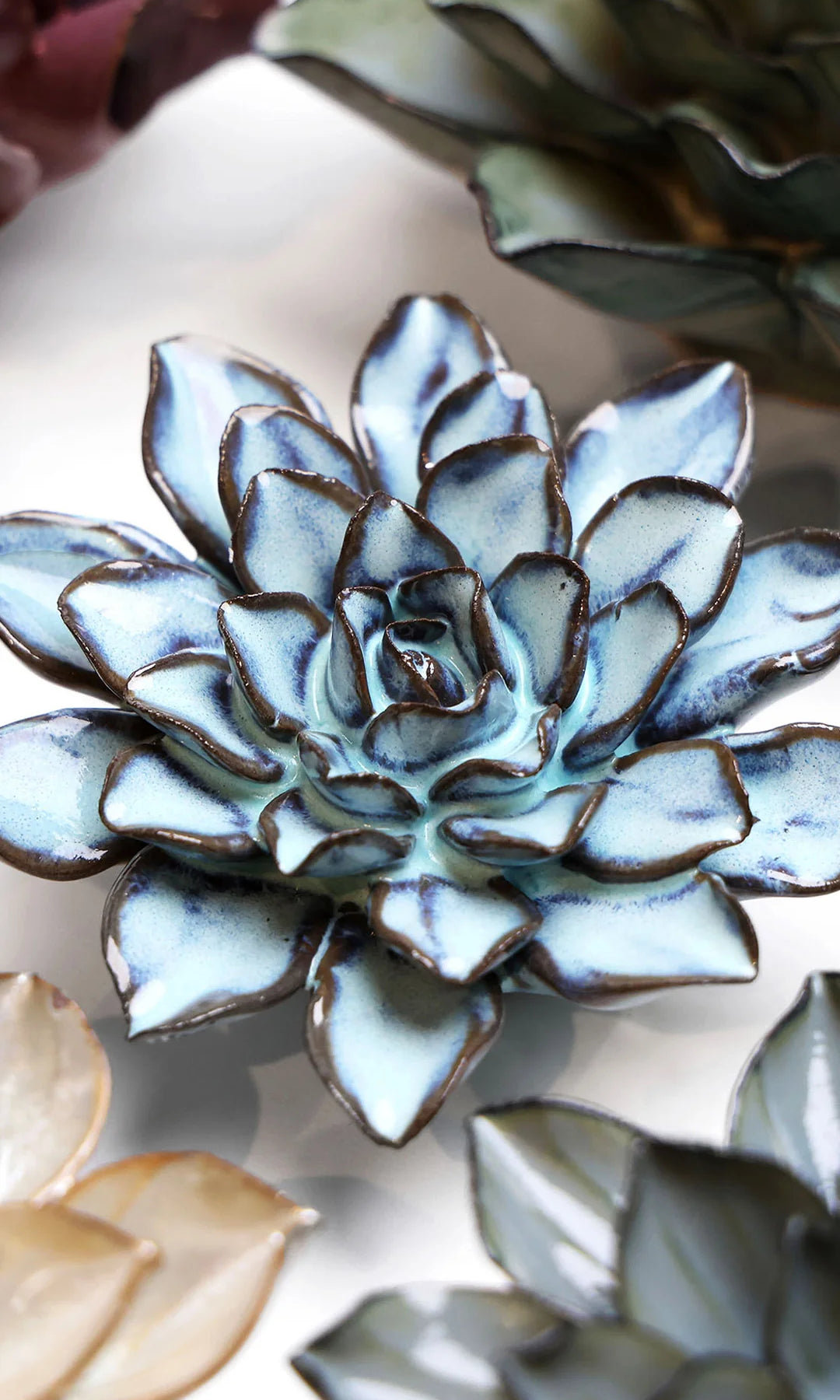 Blue Alpine Aster ceramic wall flower styled on a white table with other flowers — Chive Studio
