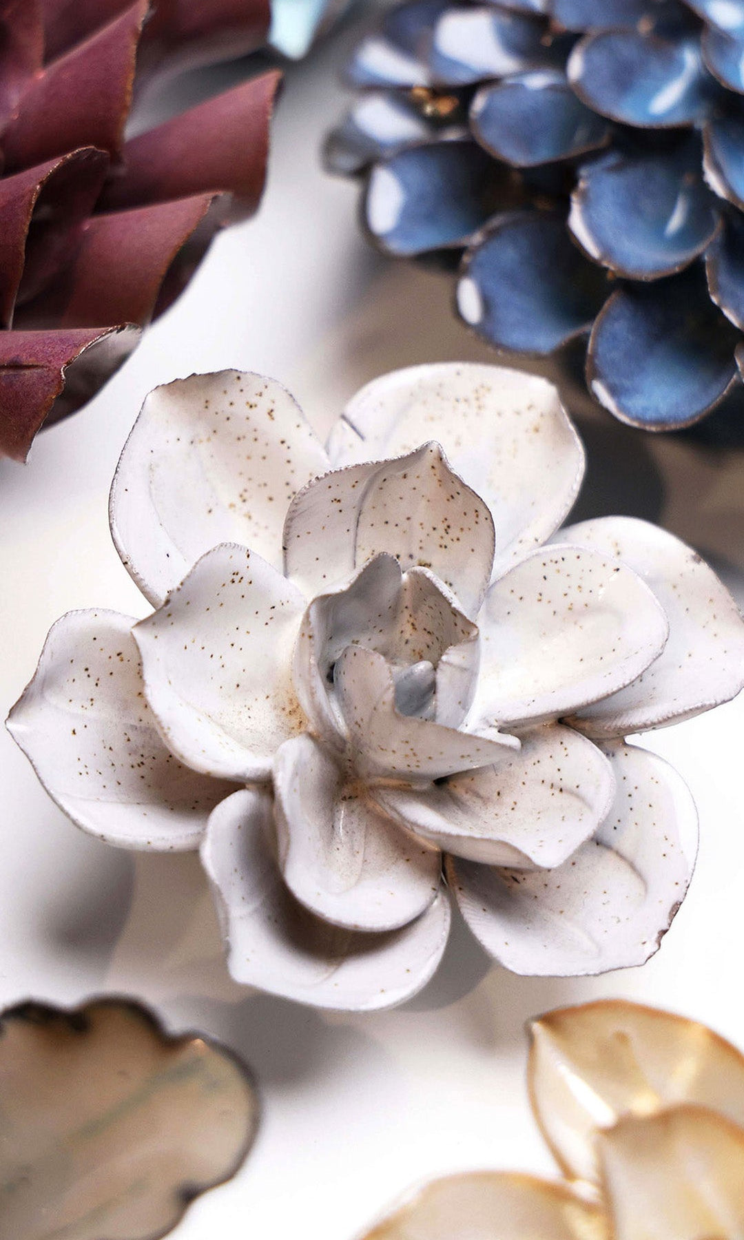 Cement Aqualla Gardenia ceramic wall flower styled on a white table with other flowers — Chive Studio