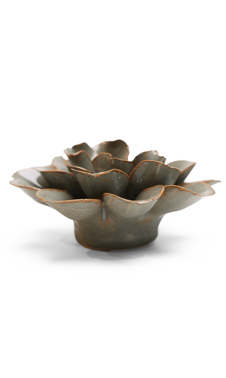 A ceramic flower-shaped bowl with a textured, petal-like surface and a rustic brown glaze, photographed on a clean white background.
