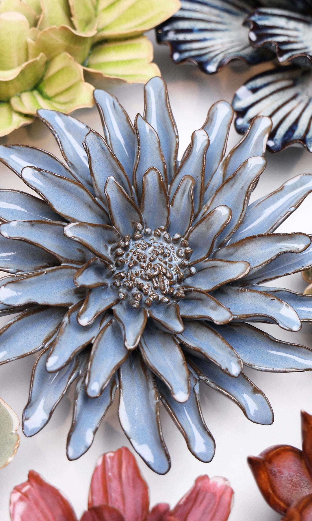Blue Grey Gerbera Daisy ceramic wall flower styled on a white table with other flowers — Chive Studio