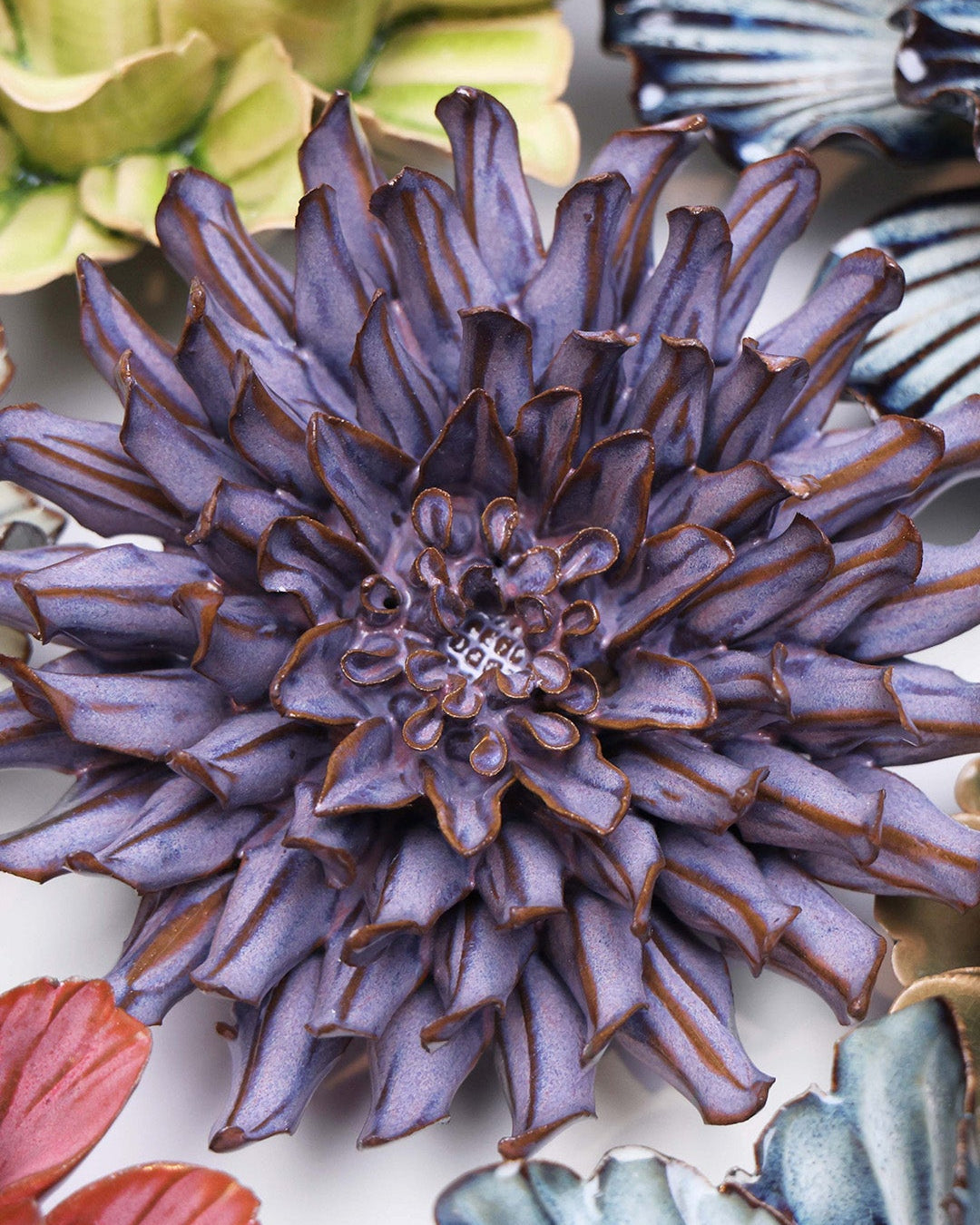 Violet Blue Fleur De Lis ceramic wall flower styled on a white table with other flowers — Chive Studio