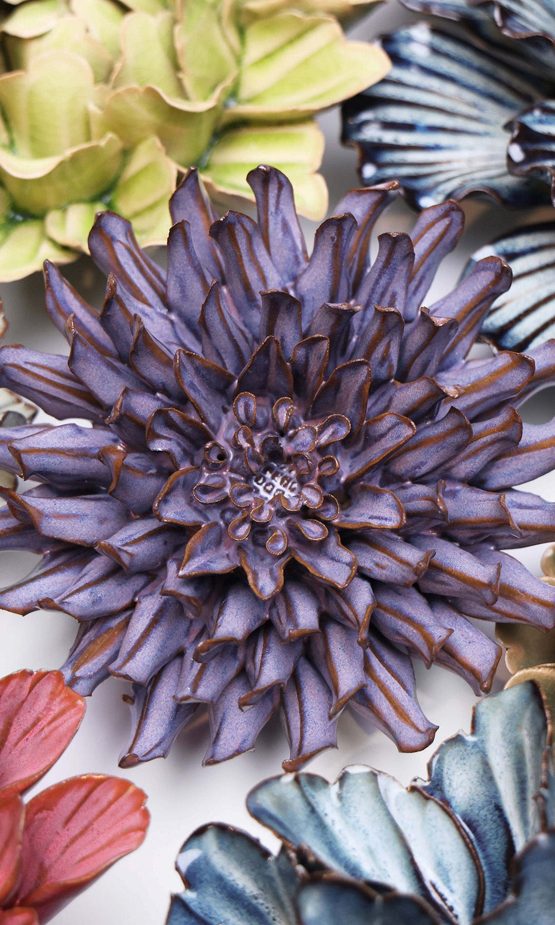 Violet Blue Fleur De Lis ceramic wall flower styled on a white table with other flowers — Chive Studio