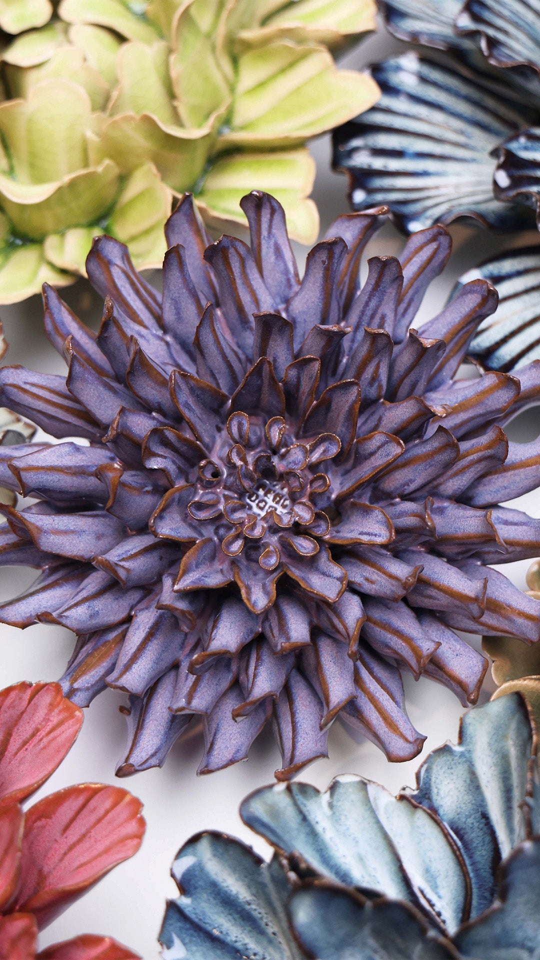 Violet Blue Fleur De Lis ceramic wall flower styled on a white table with other flowers — Chive Studio