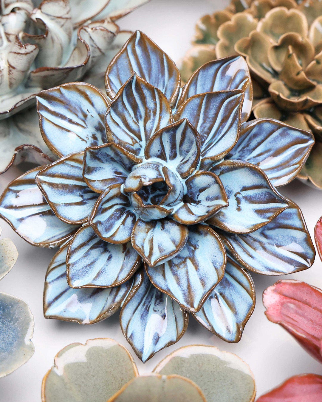 Blue Frikartii Aster ceramic wall flower styled on a white table with other flowers — Chive Studio