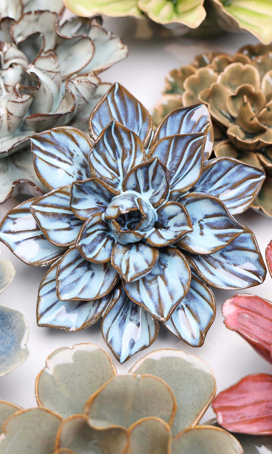 Blue Frikartii Aster ceramic wall flower styled on a white table with other flowers — Chive Studio