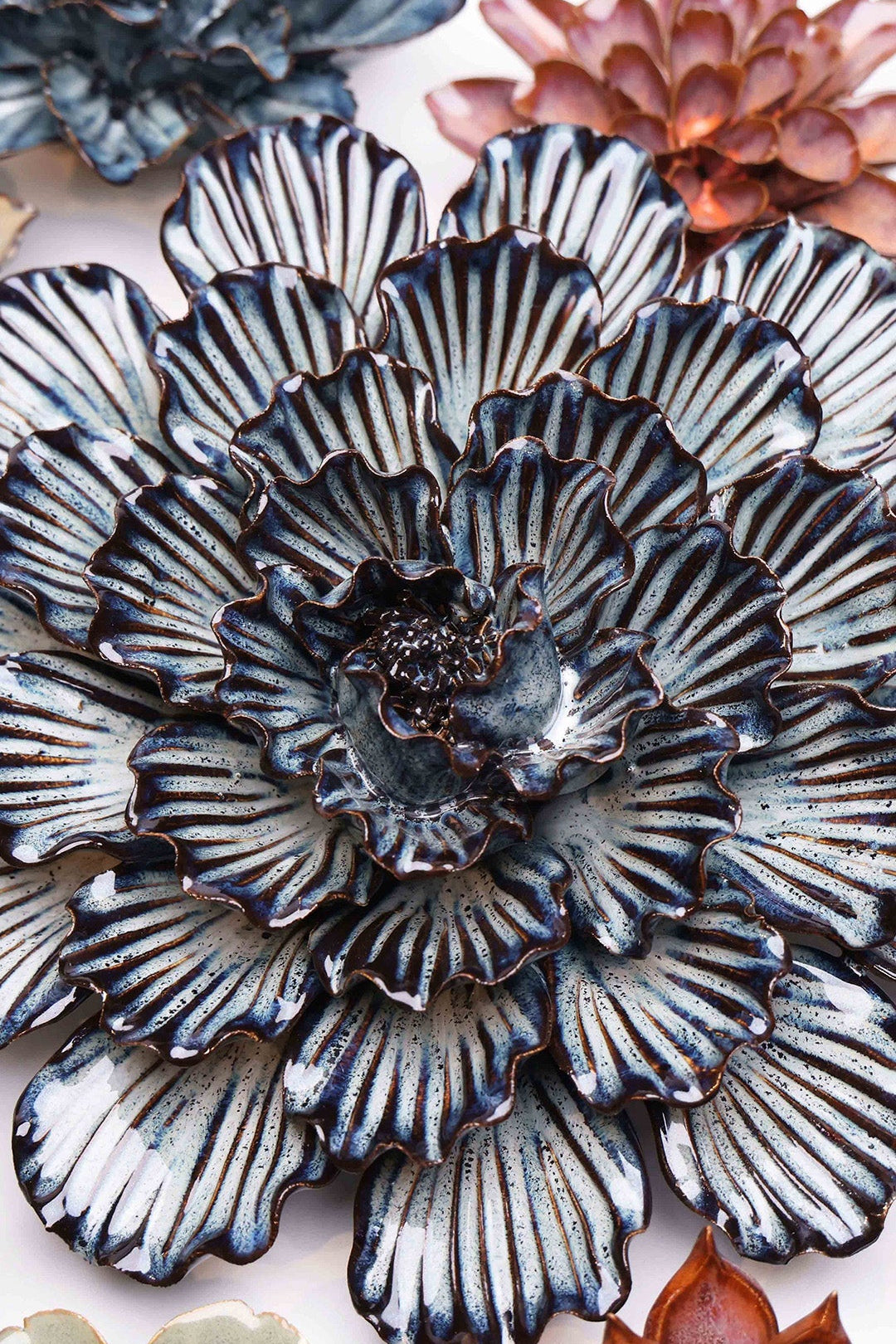Navy Blue Dinner Plate Dahlia ceramic wall flower styled on a white table with other flowers — Chive Studio
