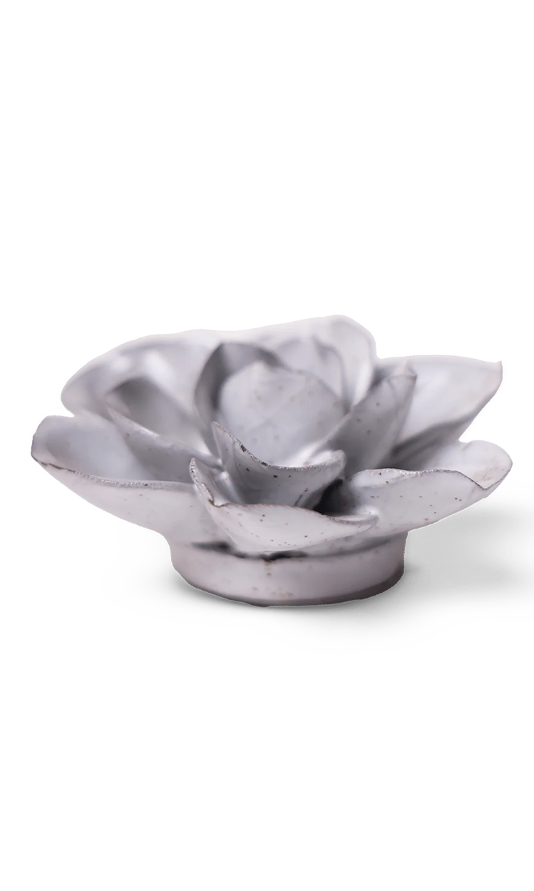 A small sculptural flower-shaped object in a matte light gray finish with subtle speckling, photographed on a clean white background.