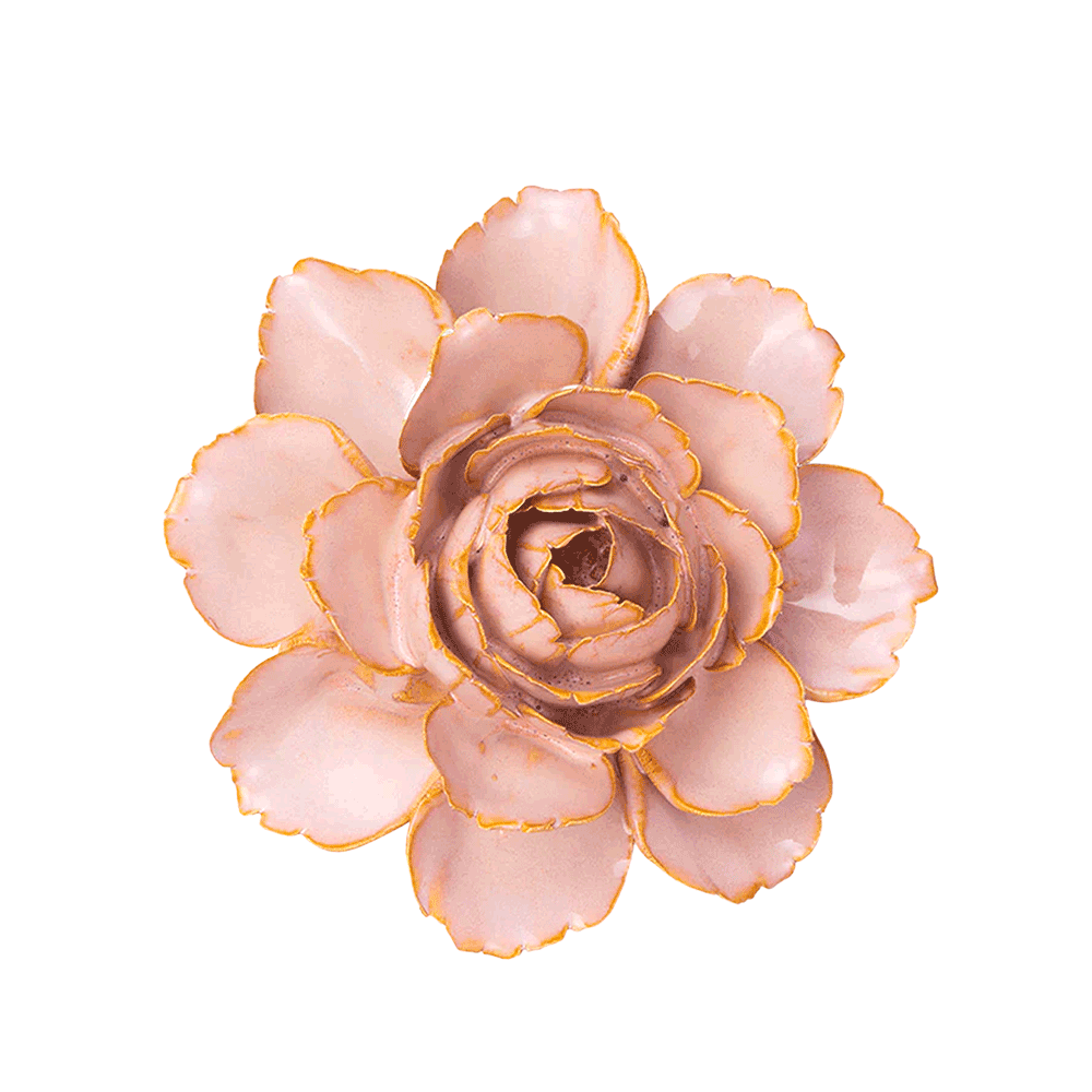 A single artificial flower bloom with pale blush pink petals and metallic gold edging, photographed from above on a plain white background.