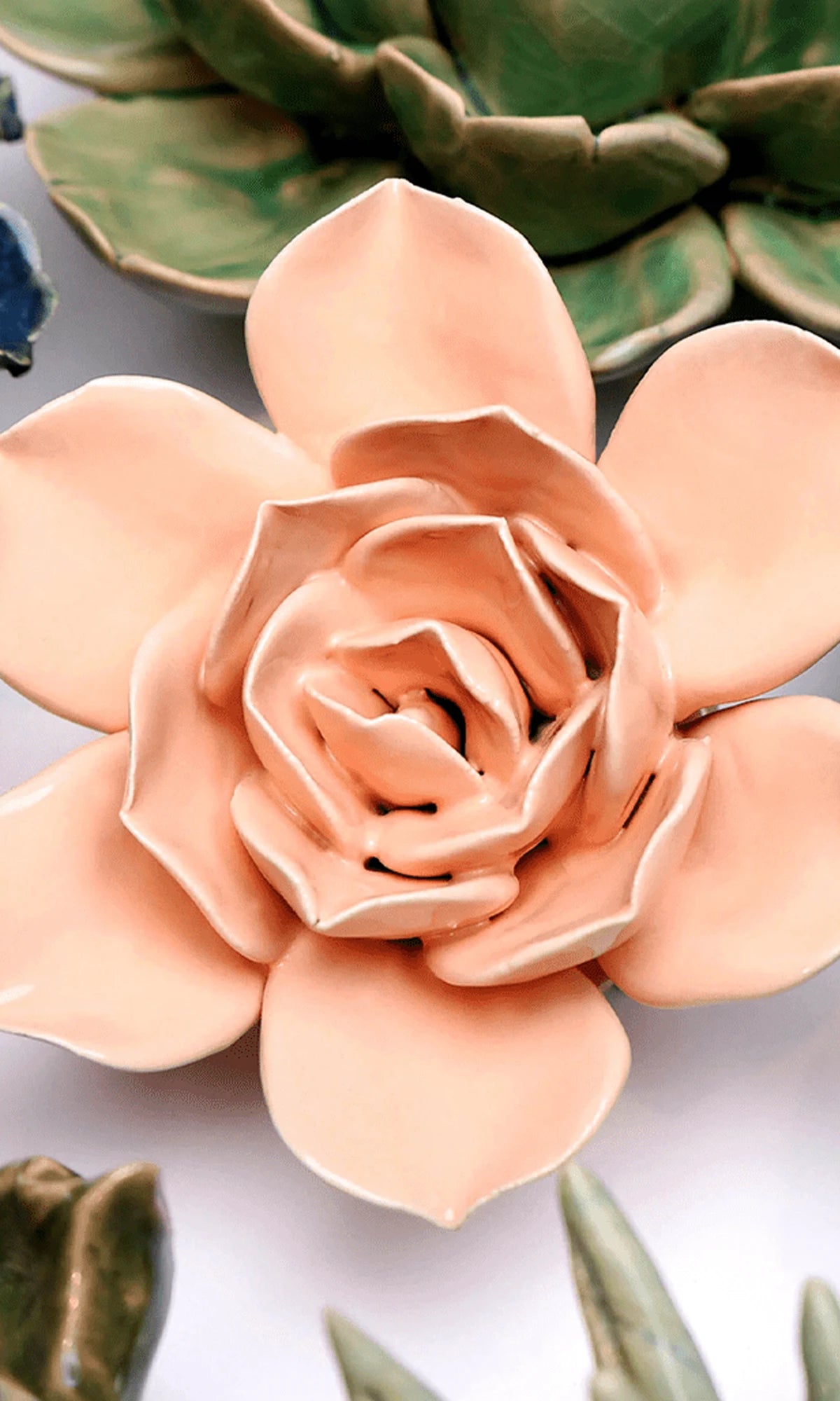 Close-up of the Chive December Birth Flower Narcissus apricot pink ceramic flower among assorted Chive ceramic flowers.