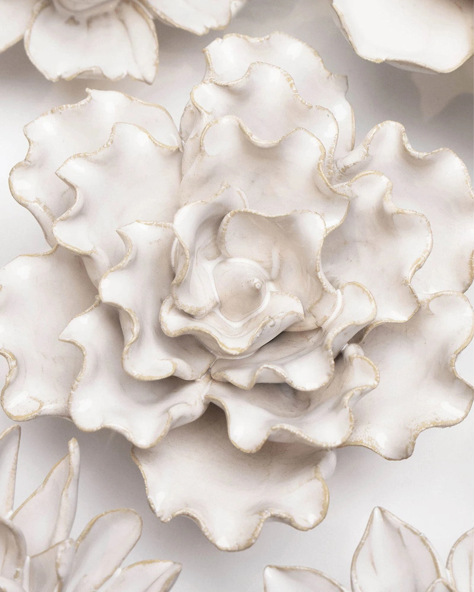 Close-up of the Chive January Birth Flower Snowdrop white ceramic flower among assorted Chive ceramic flowers.