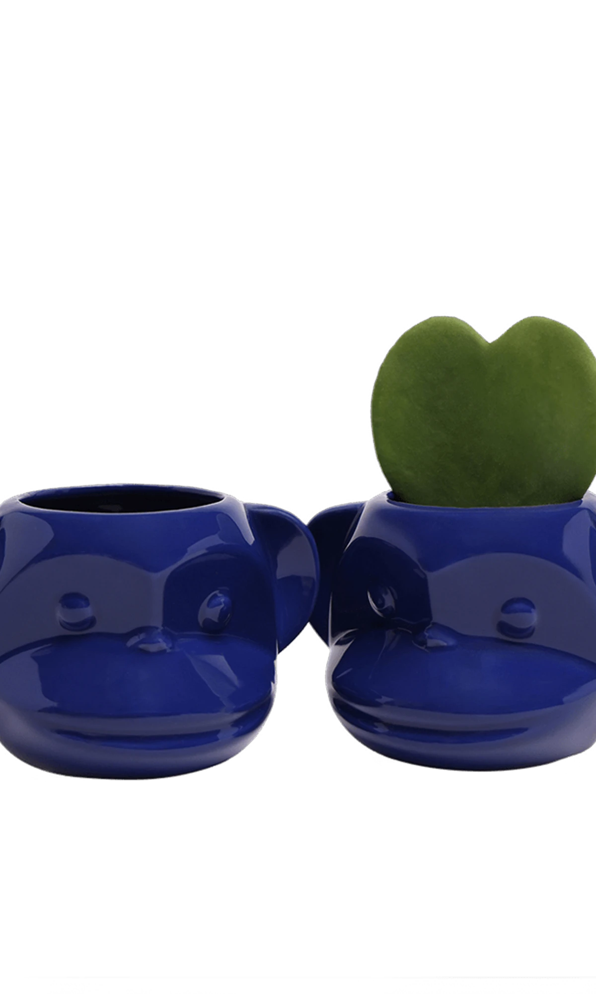 Two Chive Funky Monkey Blue glazed ceramic monkey shaped planters styled with a small plant.