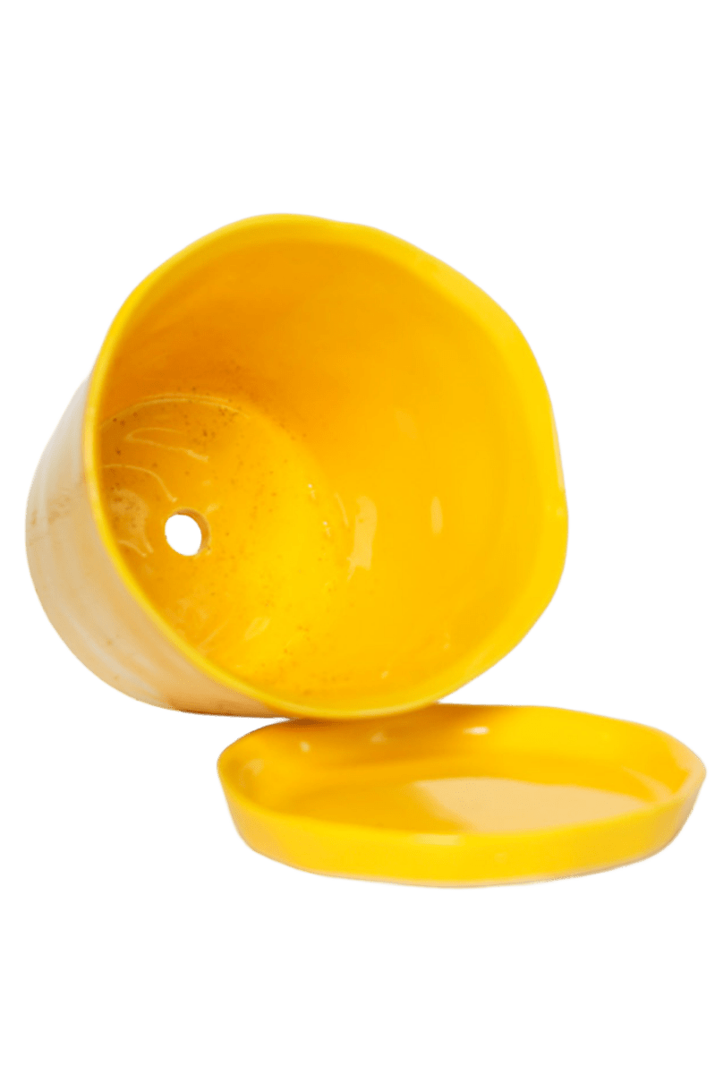 Close-up of the detachable saucer and drainage hole on a Chive Tika meadowlark yellow ceramic large pot.