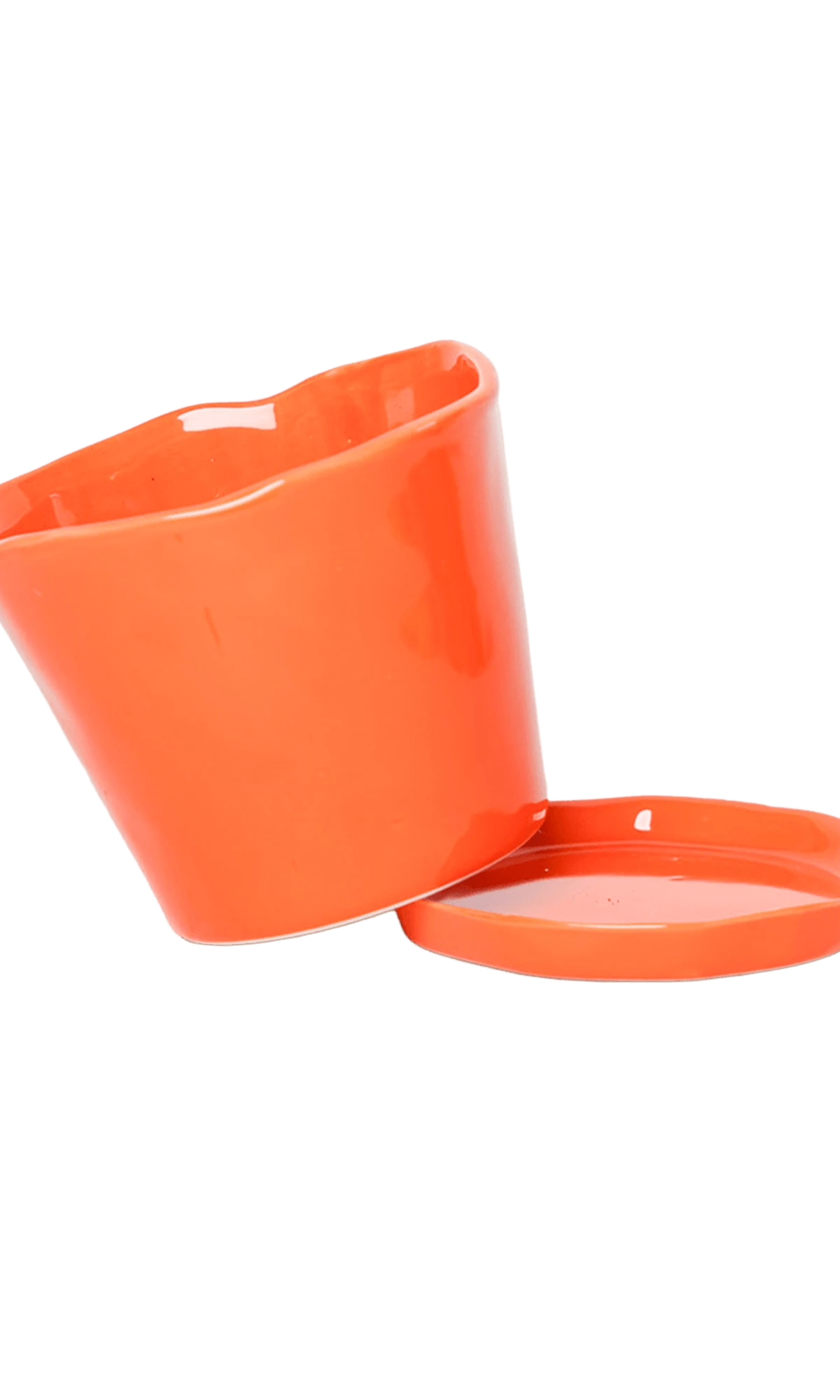 Close-up of the detachable saucer and drainage hole on a Chive Tika orange ceramic medium pot.