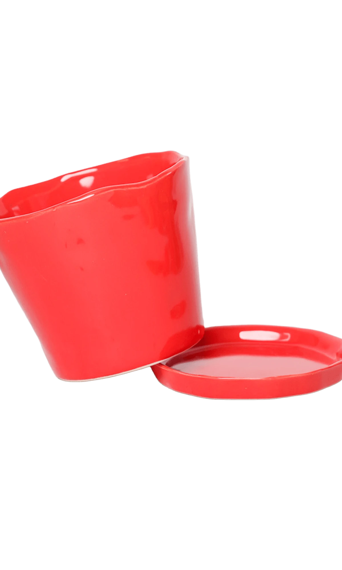 Close-up of the detachable saucer and drainage hole on a Chive Tika red ceramic medium pot.