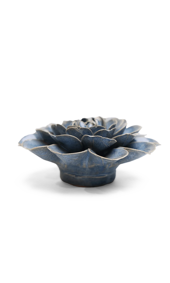 A small sculptural flower-shaped object with layered petals, shown on a clean white background. The item has a glossy dark blue glaze with lighter blue-gray highlights and a slightly distressed, rustic finish.