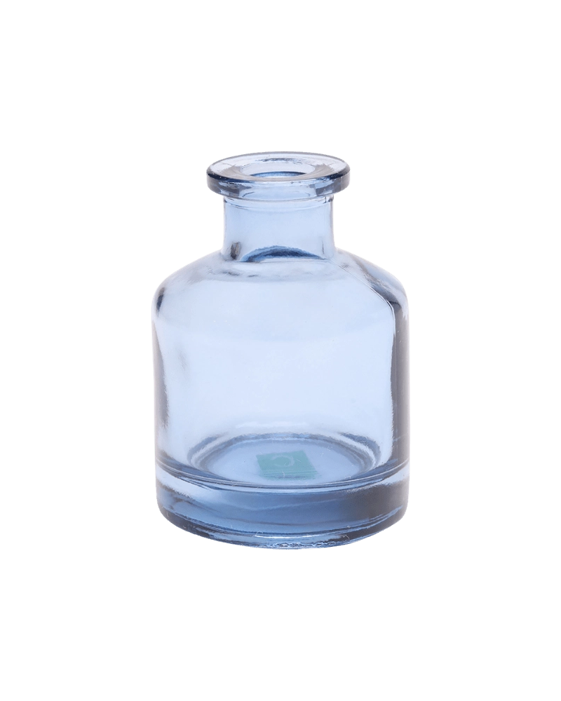 Chive Loft apothecary glass bud vase in medium blue with a tall cylindrical silhouette and wide lip.
