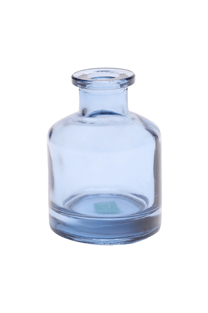 Chive Loft apothecary glass bud vase in medium blue with a tall cylindrical silhouette and wide lip.