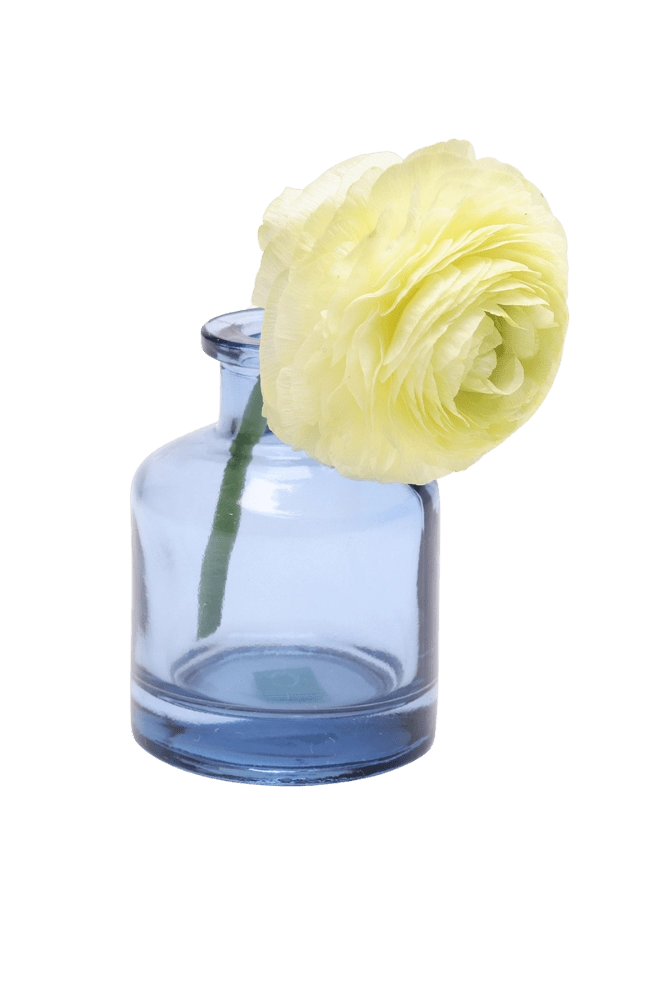 Chive Loft apothecary glass bud vase in medium blue, shown from a side angle with a yellow ranunculus.