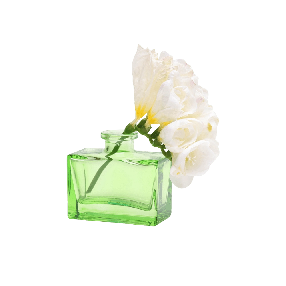 Chive Loft square glass bud vase in green styled with a stem of white freesia blooms.