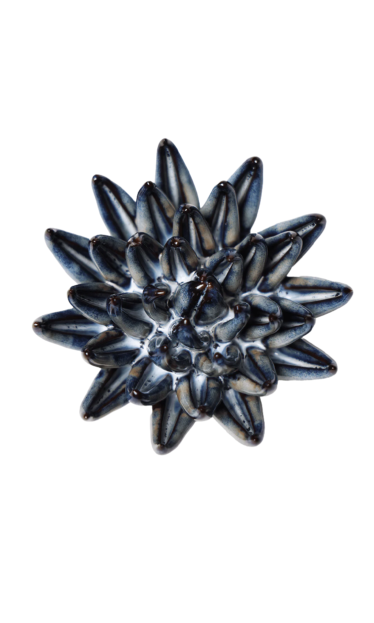 A single round button with a textured, starburst-like pattern of dark blue, black, and white stripes, shown on a plain white background.
