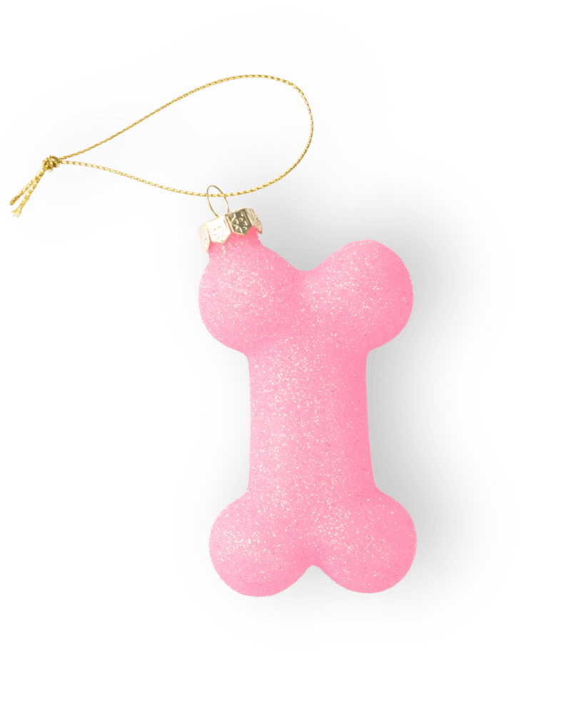Chive glass dog bone ornament in pink with a gold cord hanger.