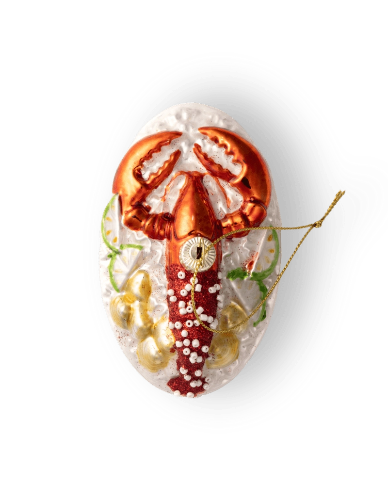 Chive glass lobster ornament, overhead view on a textured white plate.