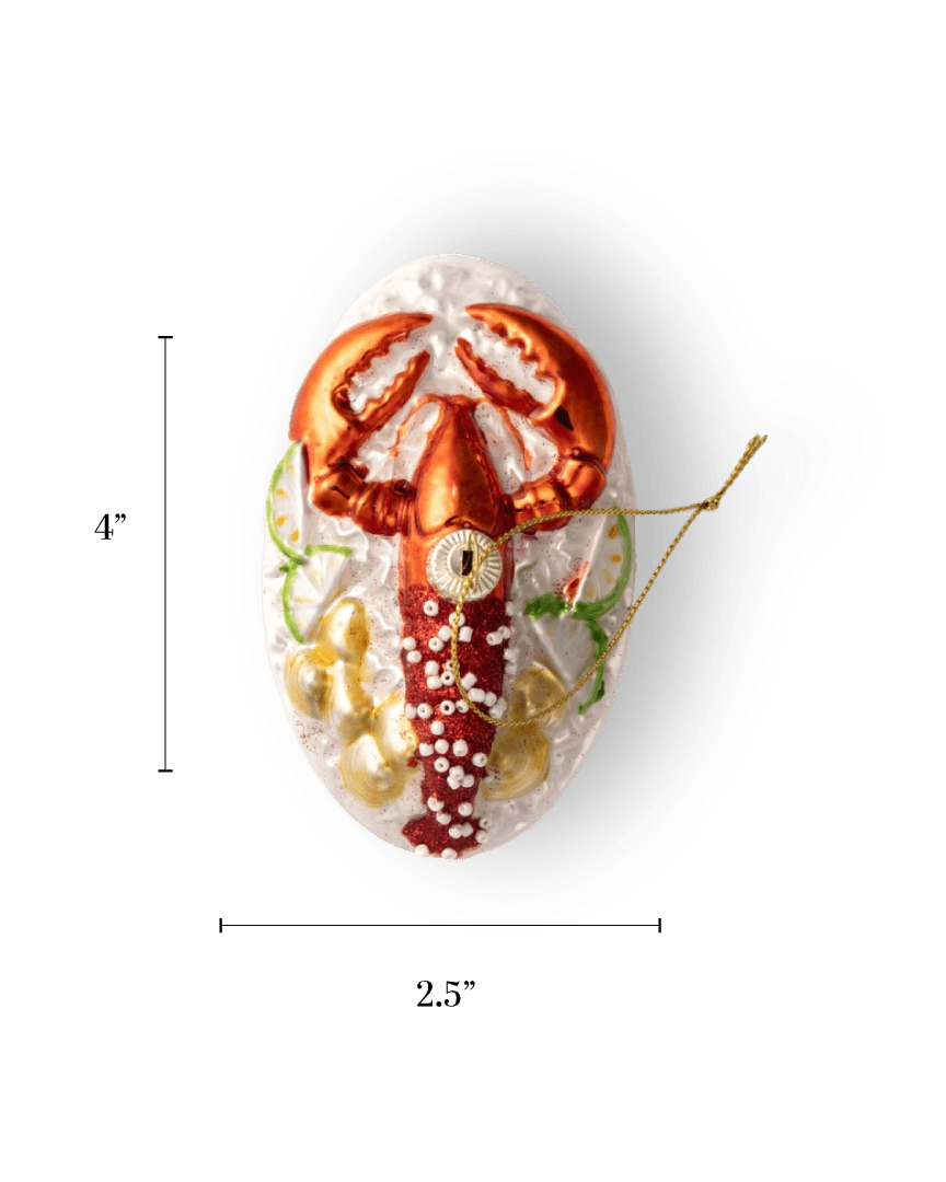 Chive glass lobster ornament on a plate with red claws and beaded garnish.