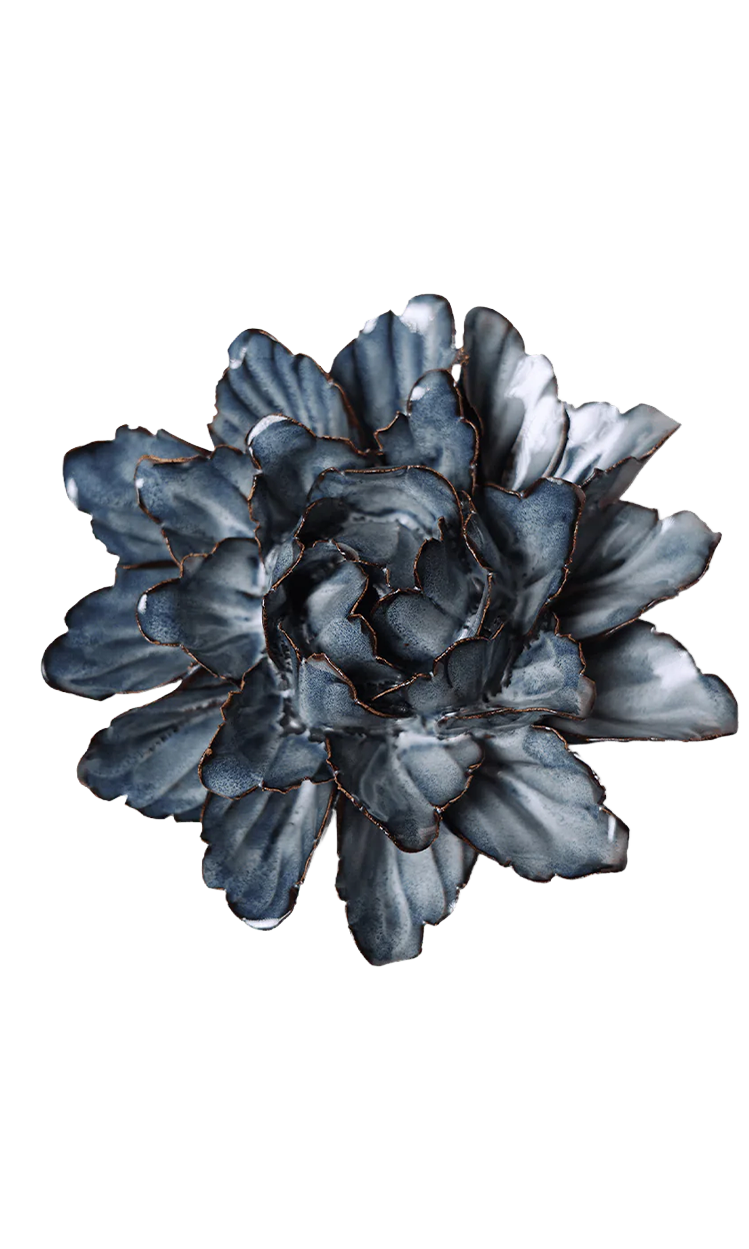 A sculptural metal wall flower with layered petals in a slate blue-gray finish and dark copper-toned edging, shown against a plain white background.